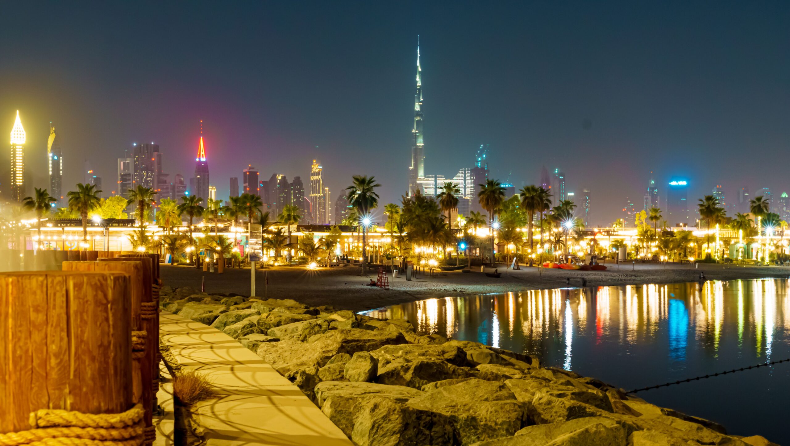 A scenic view of Downtown Dubai with the Burj Khalifa skyscraper illuminated by lights at night